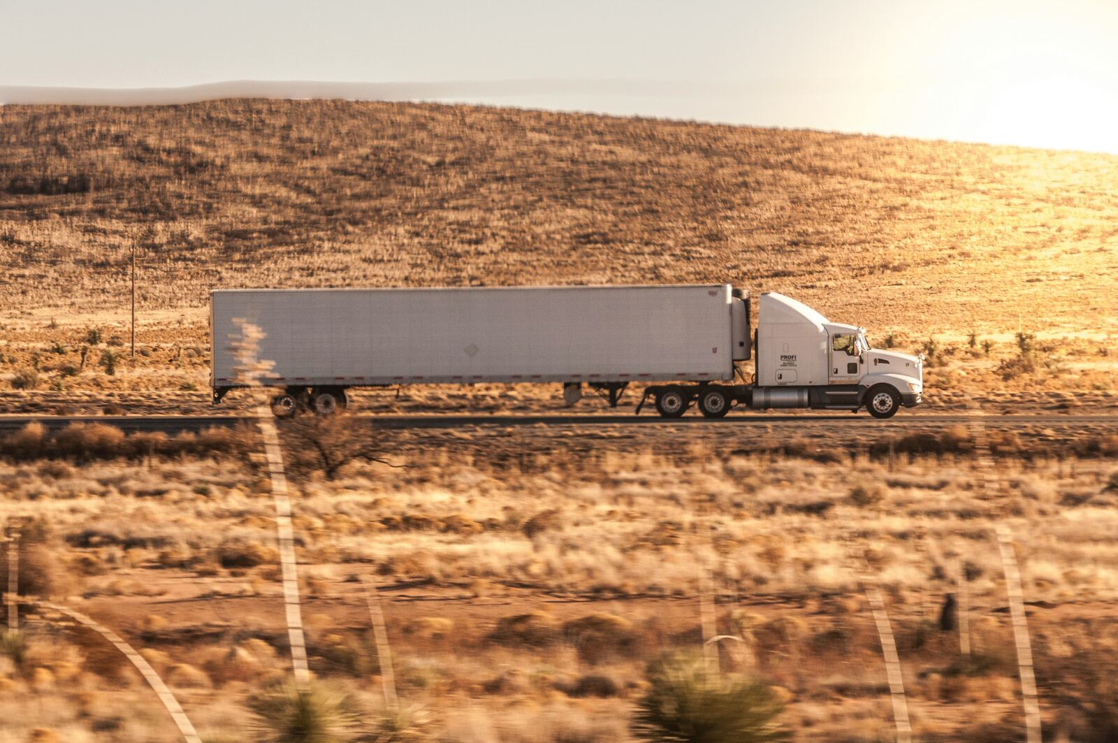 Semi truck on highway at sunset